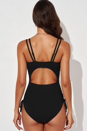 Black ribbed one-piece swimsuit with cutout back and adjustable tie sides.