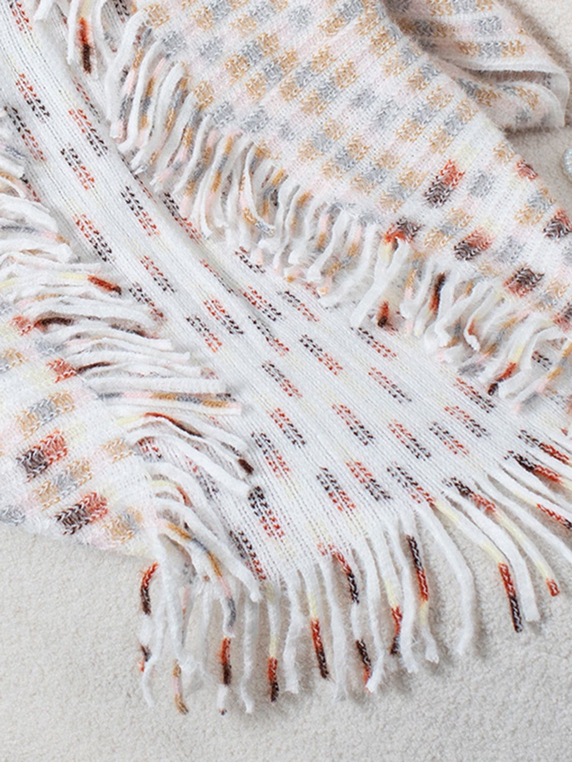 Textured fringe shawl cardigan in white with multicolor woven pattern and fringe details.