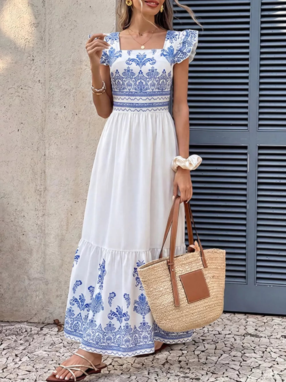 White and royal blue printed square neck maxi dress with ruffled sleeves and tiered hem.