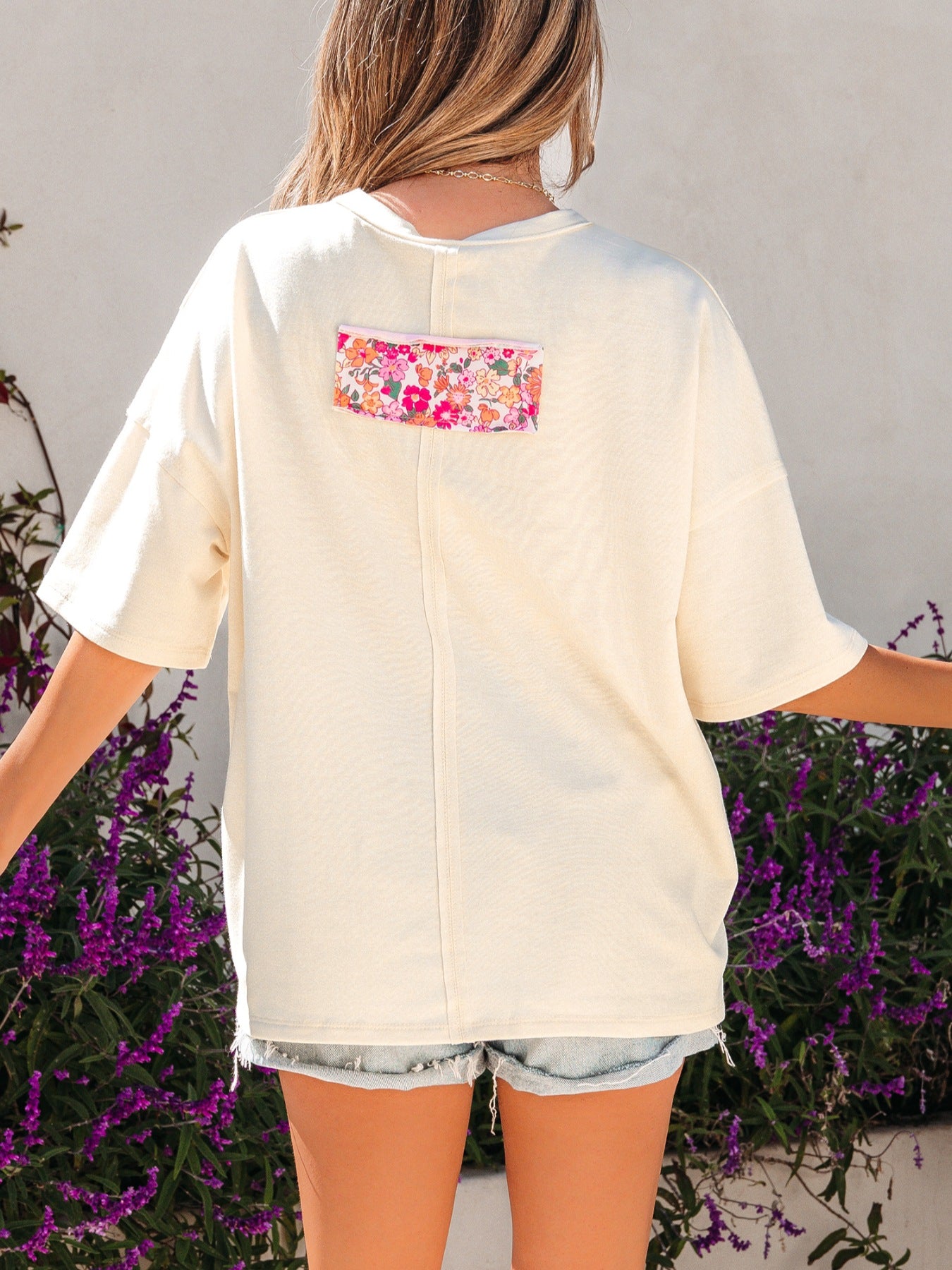 Cream cotton oversized t-shirt with floral chenille patch detail on back.