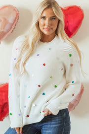 White ribbed knit sweater with colorful heart embellishments.