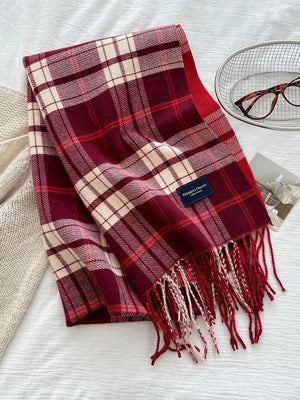 Red plaid scarf with fringe and a classic pattern.