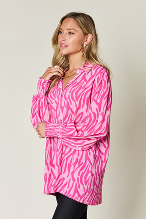 Pink zebra print blouse with shirred cuffs and collar.