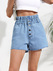 High-waisted denim paperbag shorts in medium wash with button fly and frayed hem.