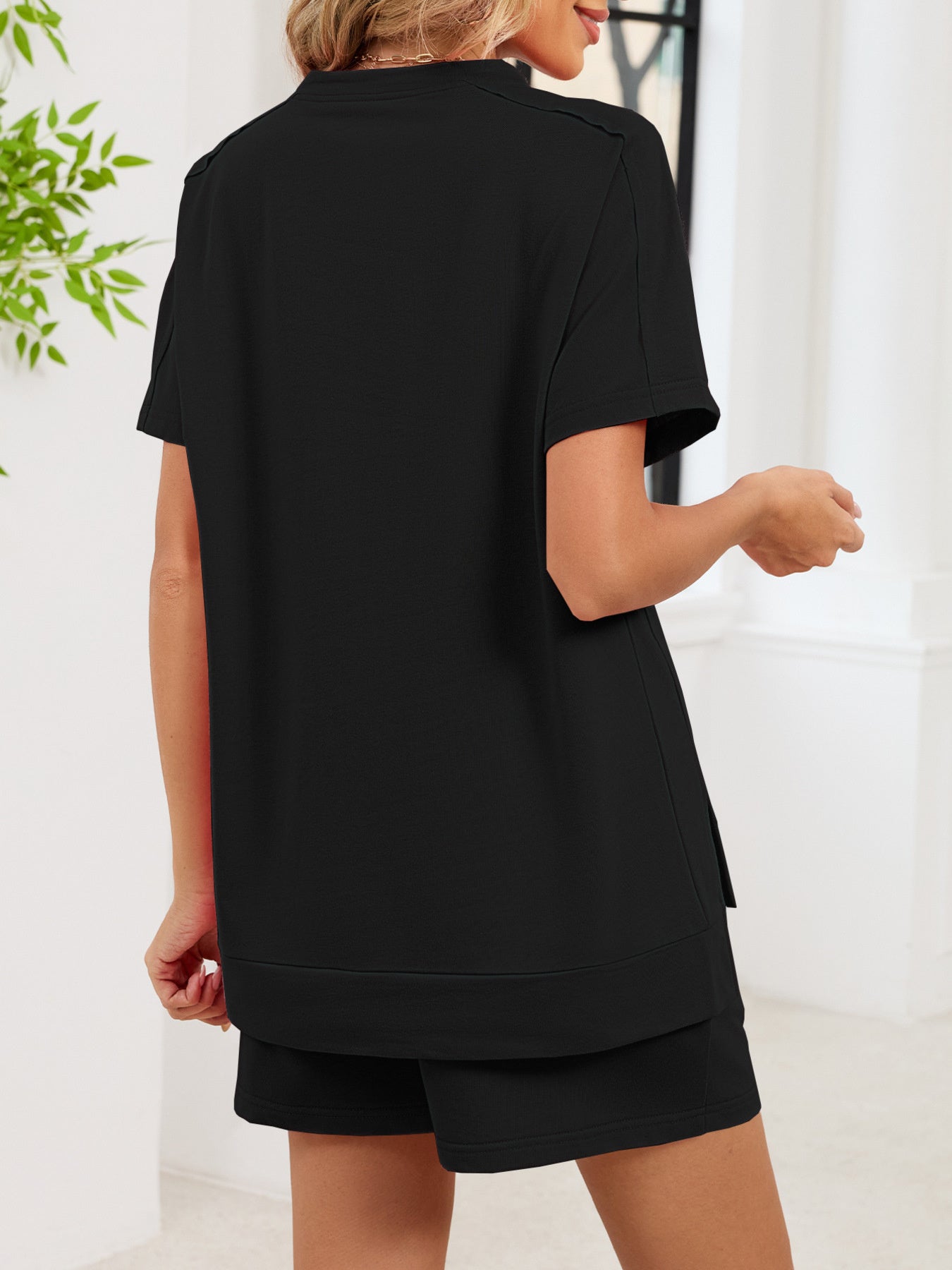 Black relaxed two-piece set with short sleeves and shorts, featuring pockets.