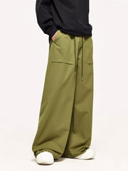 Relaxed fit yellow-green cargo pants with drawstring waist and flap pockets.