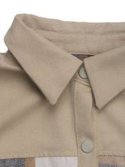 Tan cotton shacket with plaid paneling and button closure detail.