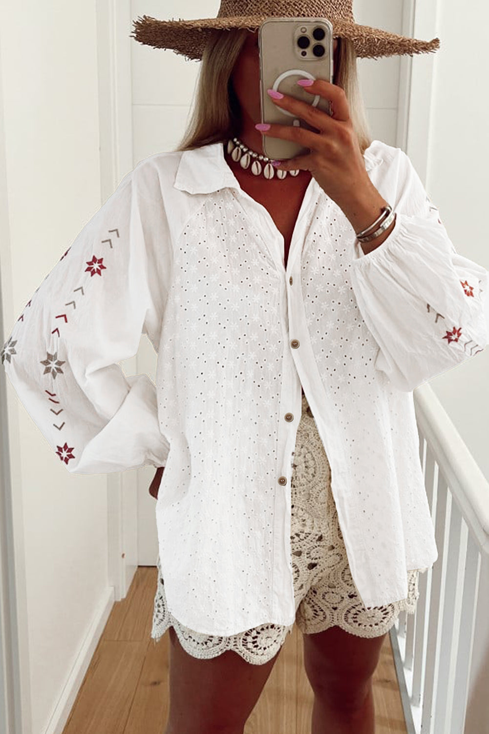 White embroidered eyelet blouse with poet sleeves and boho star details.