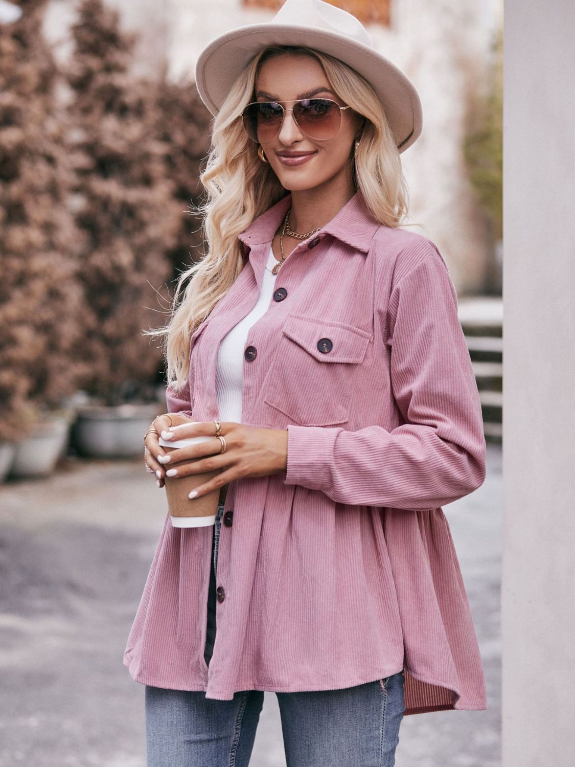 Pink corduroy peplum shirt jacket with buttoned pockets and a flared hem.