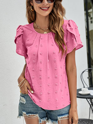 Pink textured puff sleeve dot blouse with round neckline and short sleeves.