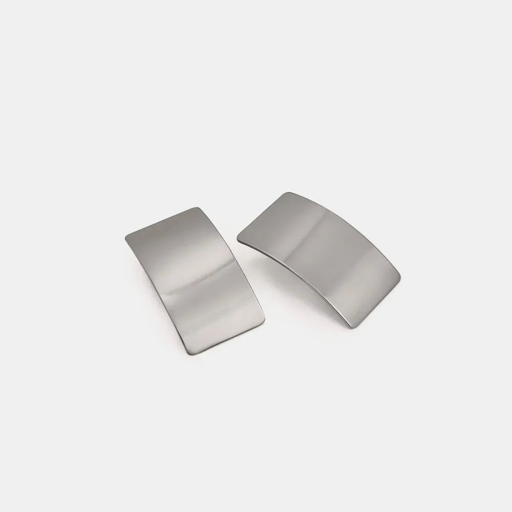 Sculpted silver-tone statement earrings with a bold, curved design.