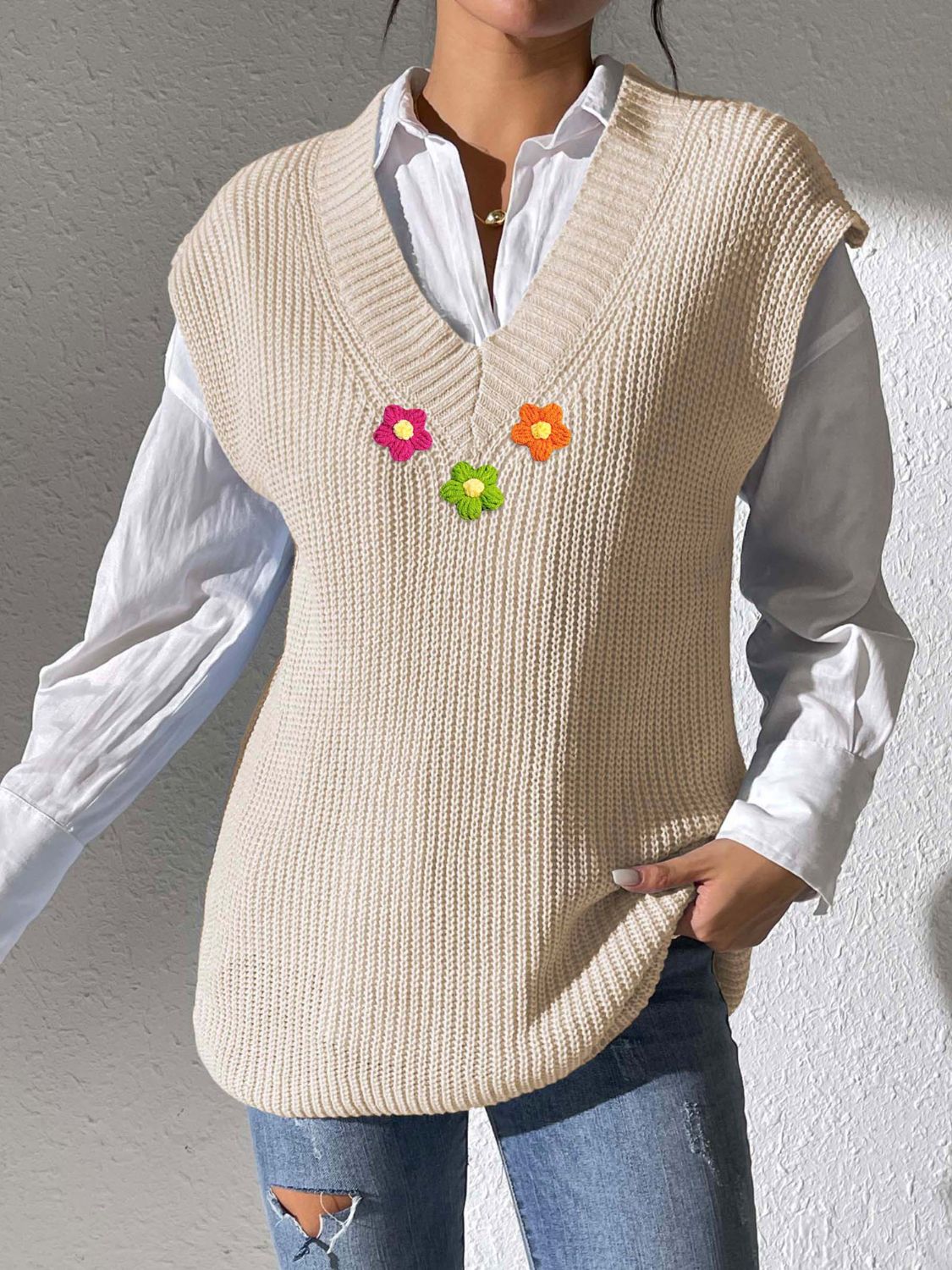 Beige ribbed knit vest with embroidered flowers and V-neck.