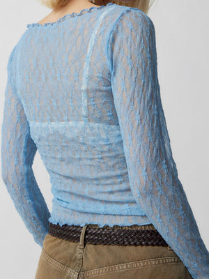 Light blue lace blouse with scalloped neckline and hem, long sleeves.