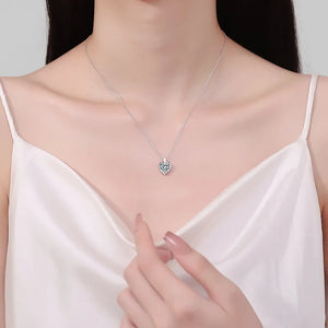 Silver chain necklace with a heart cut moissanite pendant.