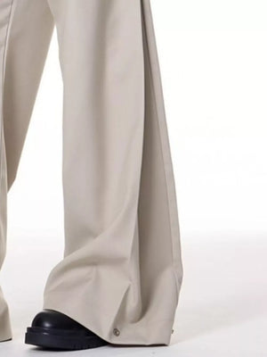 Men's beige wide-leg sweatpants with snap closure detail at the hem.