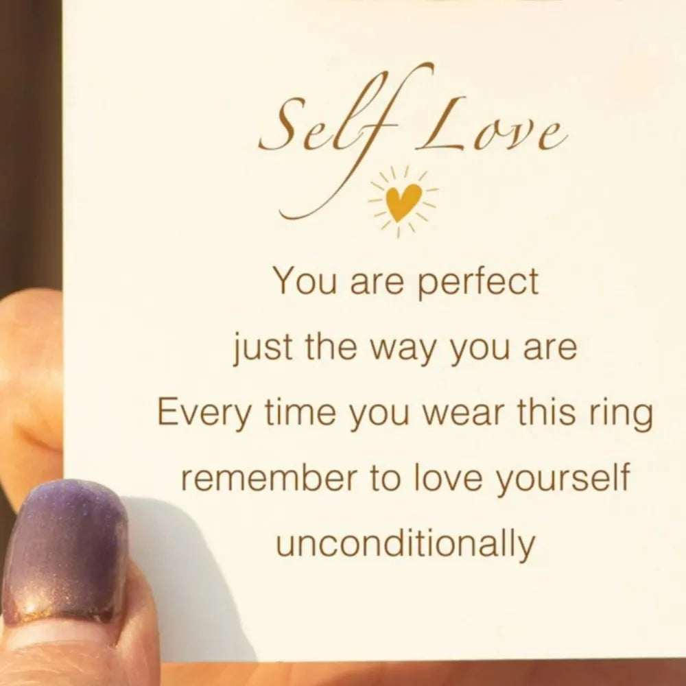 Gold two-tone heart outline ring detail on card with self-love message.