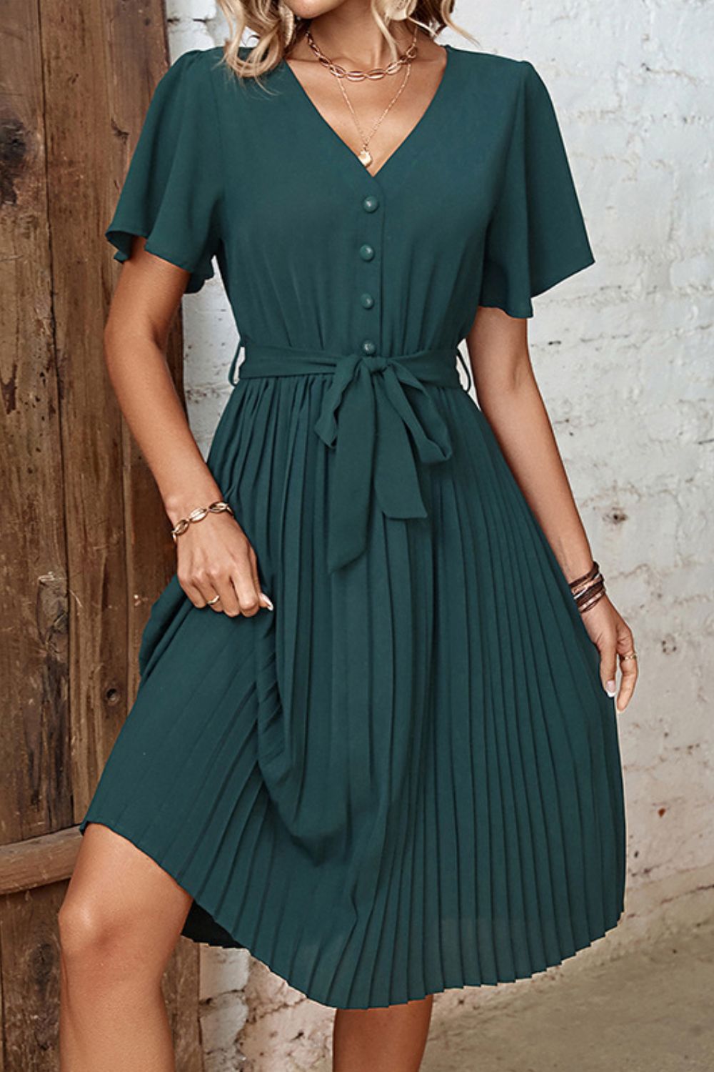Forest green midi dress with flutter sleeves, V-neck, buttons, and a belted waist.