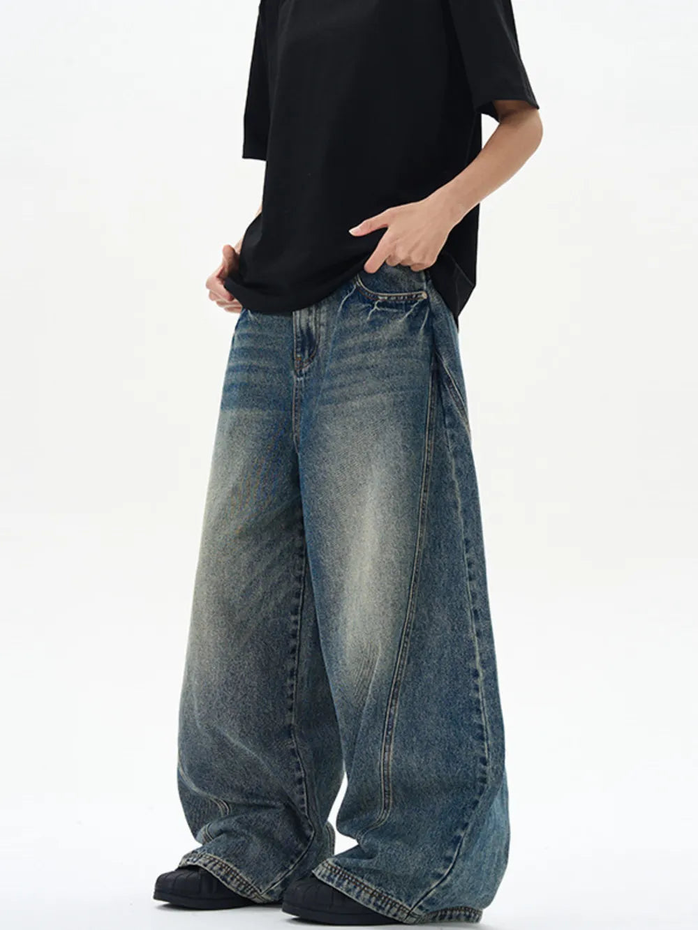 Oversized vintage-finish men's baggy jeans in dark blue denim with distressed details.