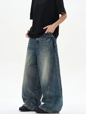 Oversized vintage-finish men's baggy jeans in dark blue denim with distressed details.