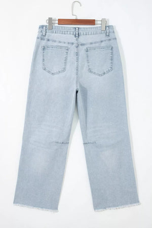 Light wash denim jeans with raw hem and utility pockets, wide leg cut.