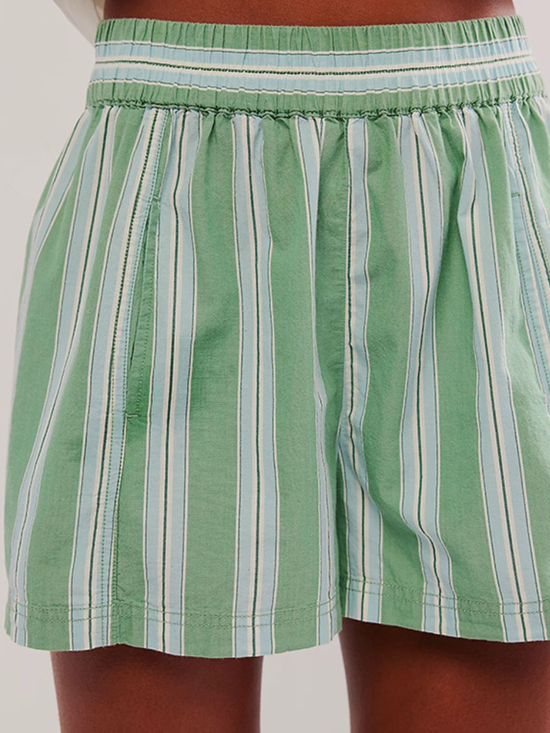 Light green striped shorts with elastic waistband and pockets