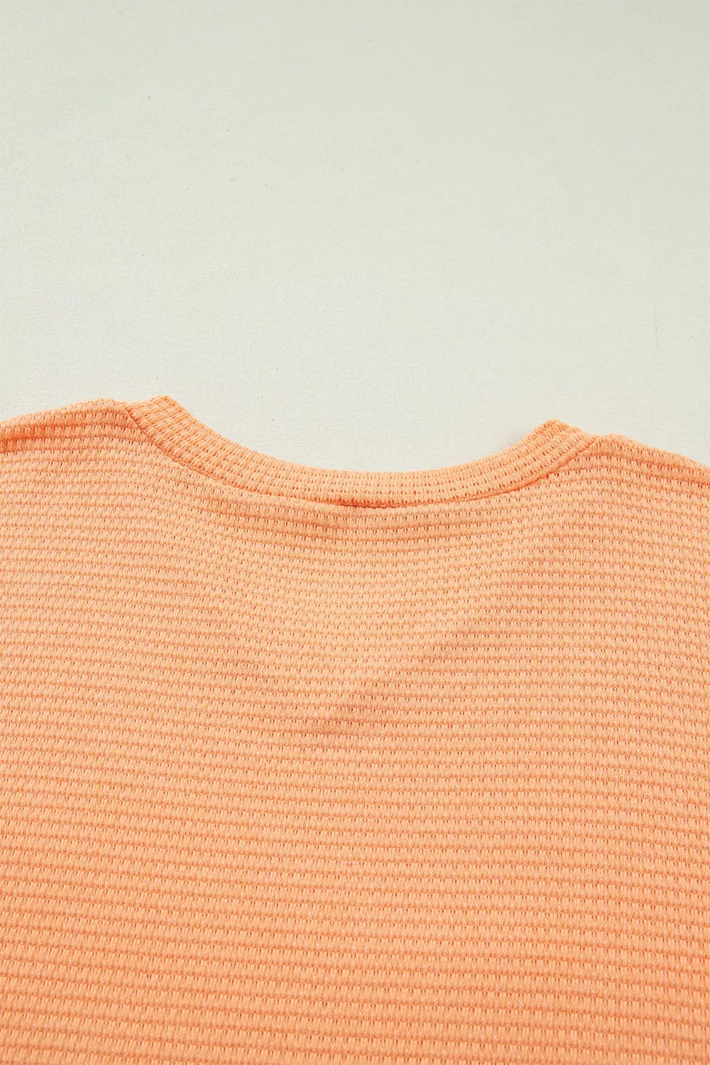 Waffle knit V-neck t-shirt in sherbet polyester with a ribbed neckline.