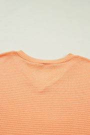Waffle knit V-neck t-shirt in sherbet polyester with a ribbed neckline.