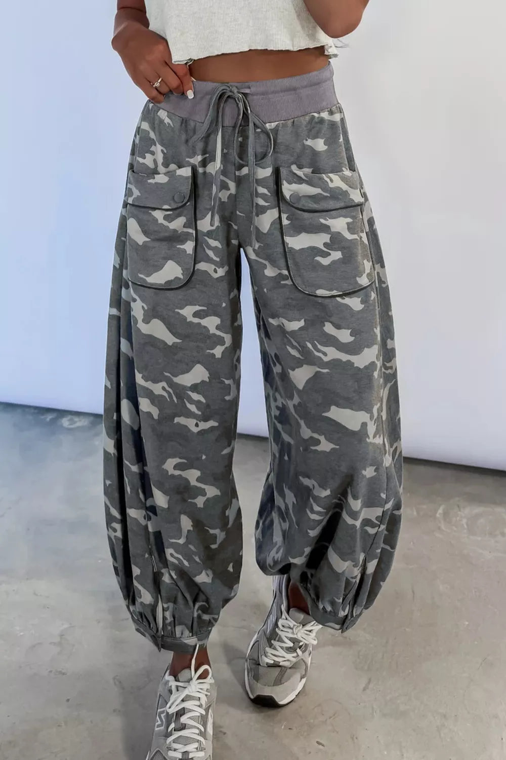 Camouflage barrel cargo pants with button-flap pockets and drawstring waist.