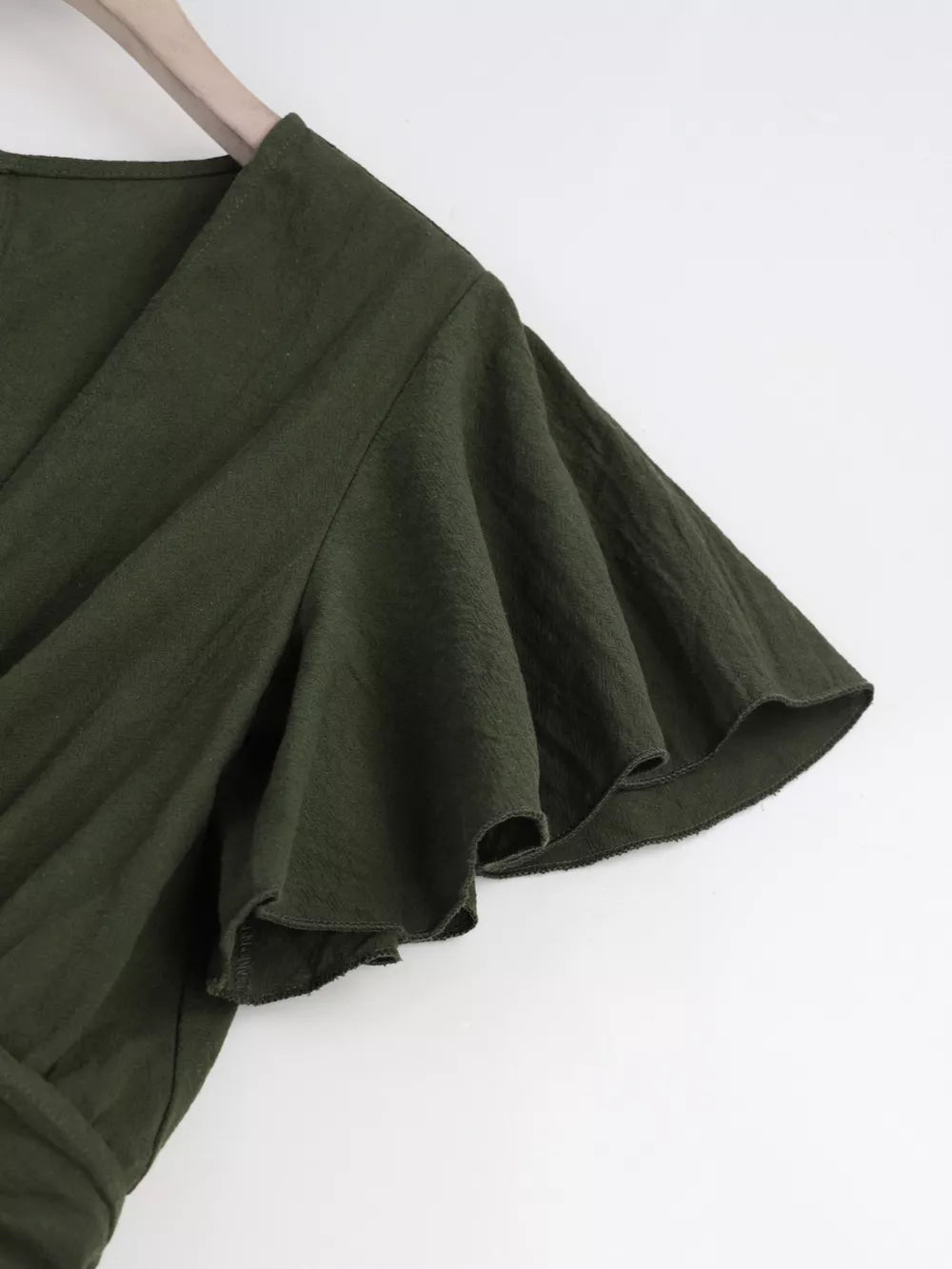 Olive green cotton romper with flutter sleeves and tie-waist detail