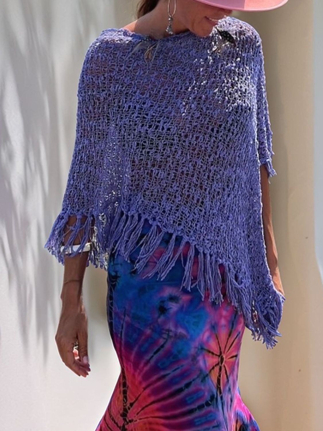 Purple open-knit poncho with boat neck and fringe trim, acrylic material.