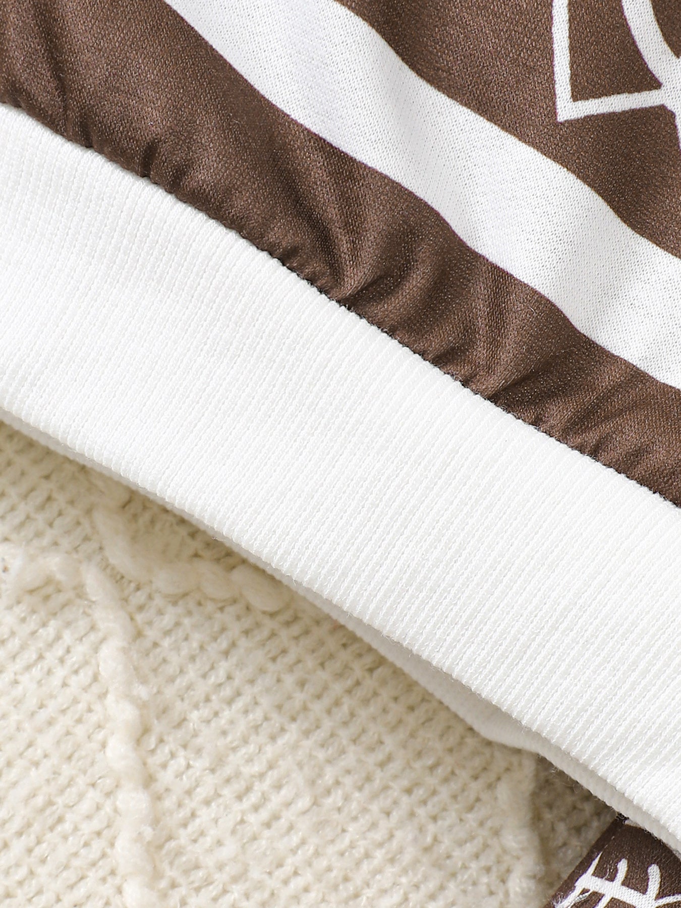 Baby top and pants set with brown and white football print and ribbed cuffs.
