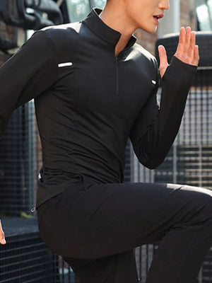 Men's black quarter-zip active t-shirt with thumbholes and reflective details.