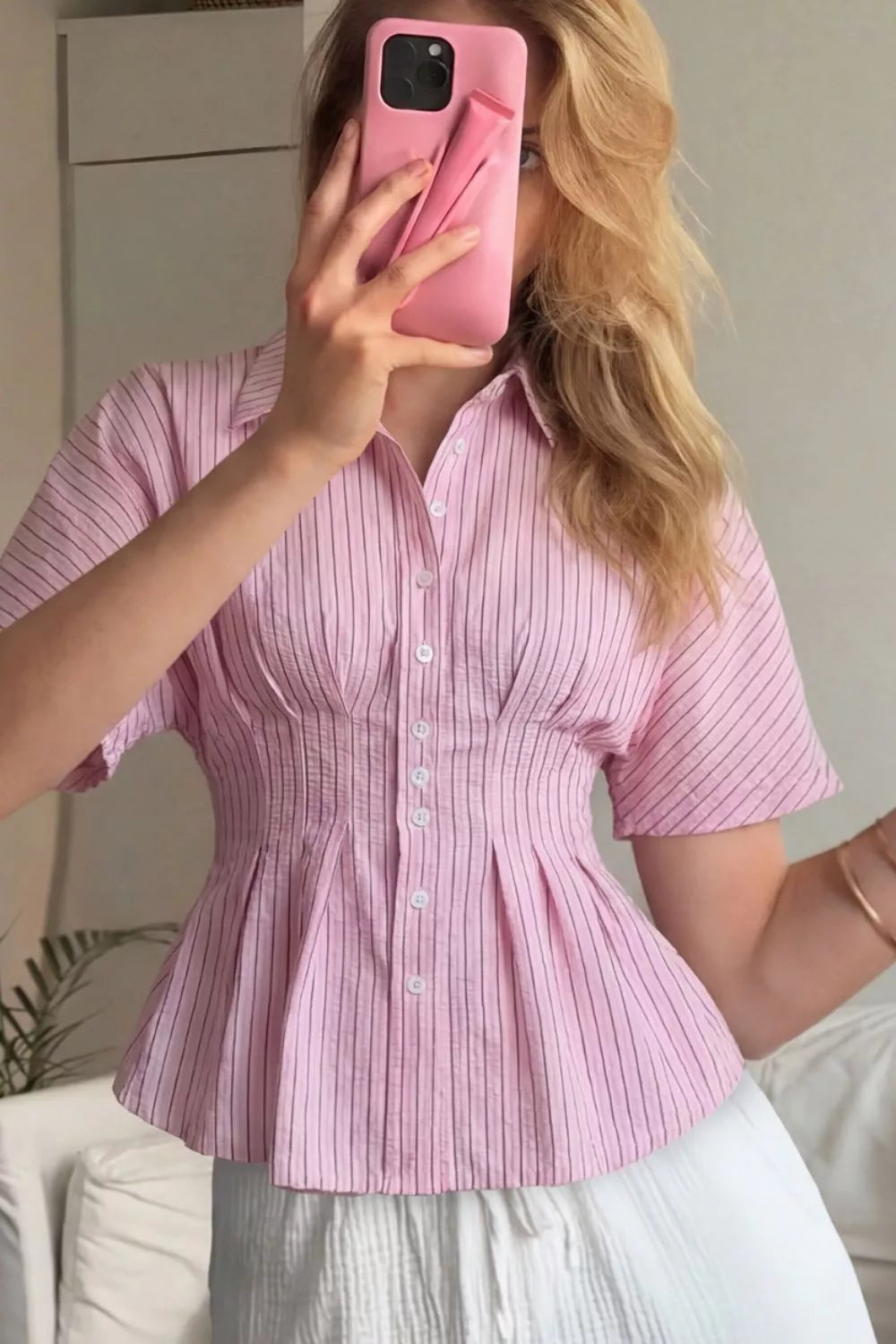 Blush pink striped peplum maternity blouse with button detail and short sleeves.