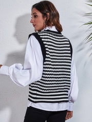 Black and white striped knit vest with a double-breasted detail, worn over a white shirt.