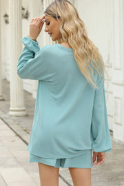 Pastel blue ribbed outfit set with long sleeves and shorts, featuring a casual and comfortable style.