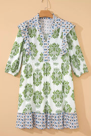 Vibrant floral ruffle mini dress with green damask print and blue geometric hem