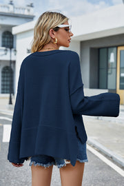 Peacock blue acrylic knit sweater with flared sleeves and split hem detail.