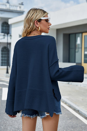 Peacock blue acrylic knit sweater with flared sleeves and split hem detail.