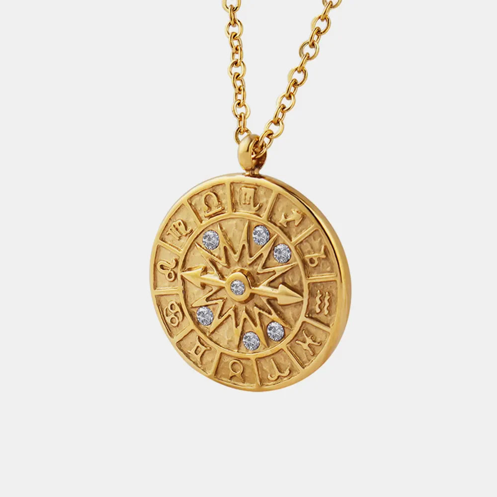 Gold zodiac compass pendant necklace with celestial details and sparkling stones.