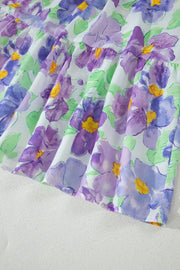 Vibrant floral mini dress with tiered ruffles and purple watercolor flowers.