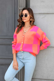 Colorblock geometric knit cardigan in pink and orange acrylic with button front.