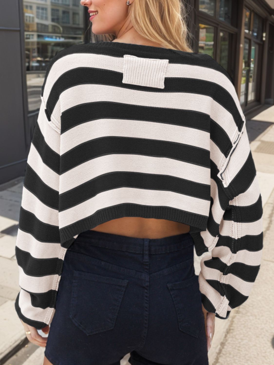 Off-shoulder cropped stripe knit sweater in black and white acrylic with a ribbed detail on the back.