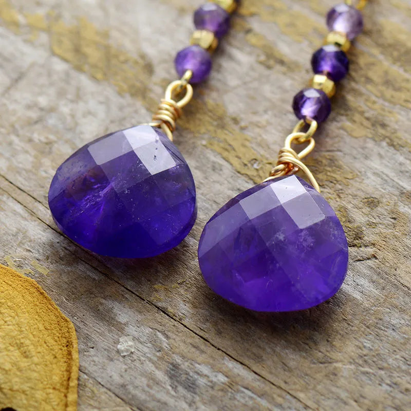 Facet drop amethyst gemstone earrings with gold-plated beads and wire wrapping.