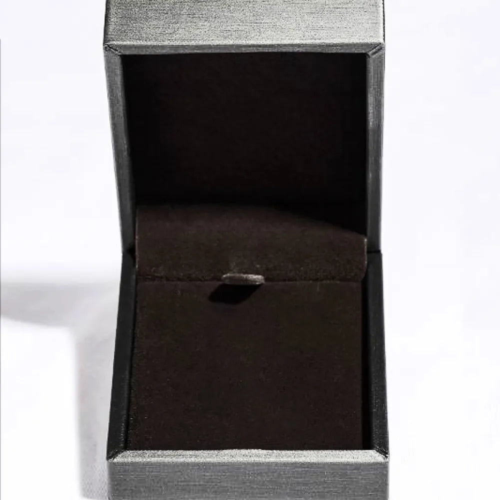 Open jewelry box with dark brown velvet lining and textured gray exterior.