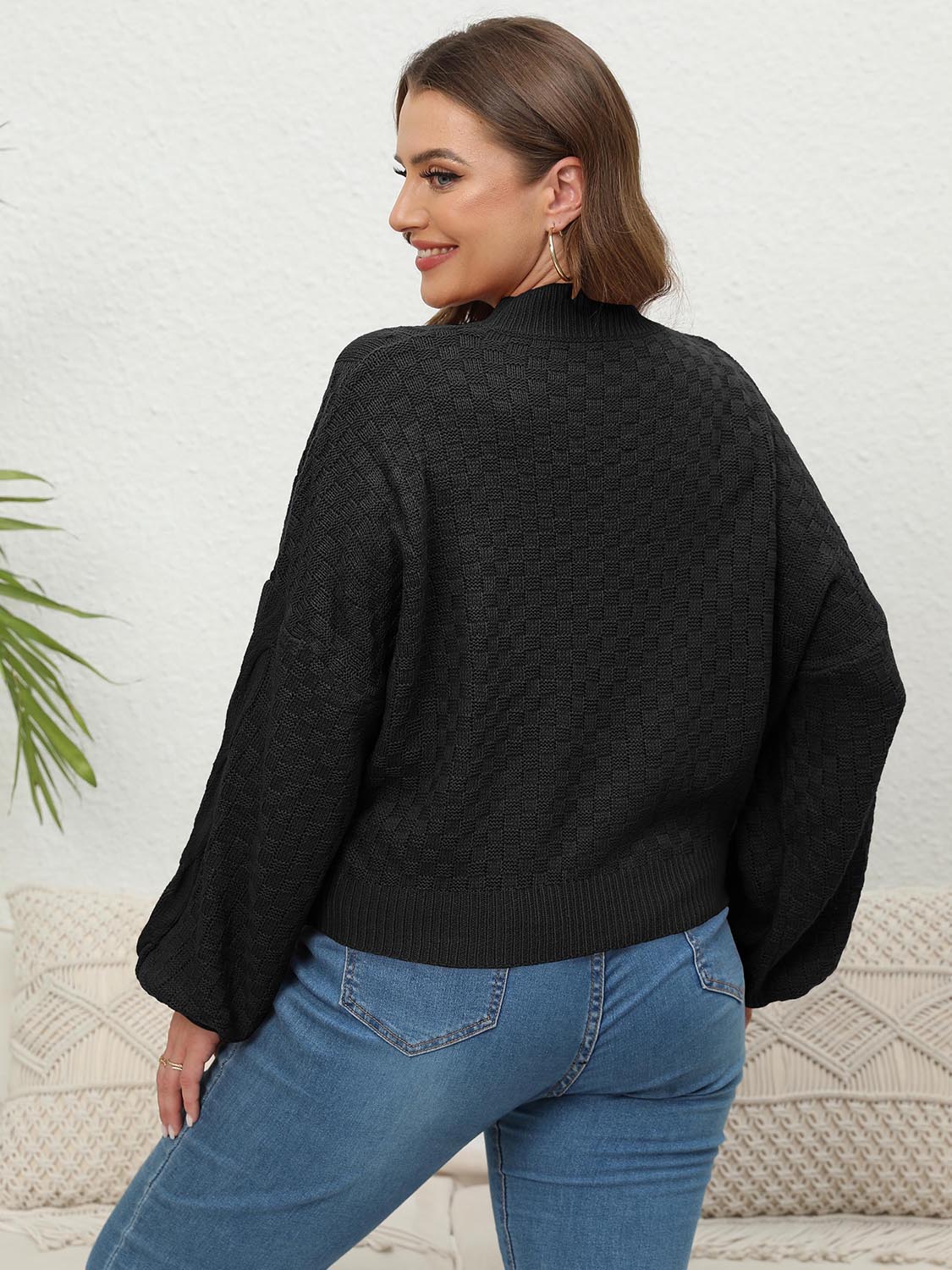 Black acrylic cable knit sweater with balloon sleeves and mock neck