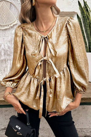 Gold peplum blouse with puff sleeves and a tie-front neckline.