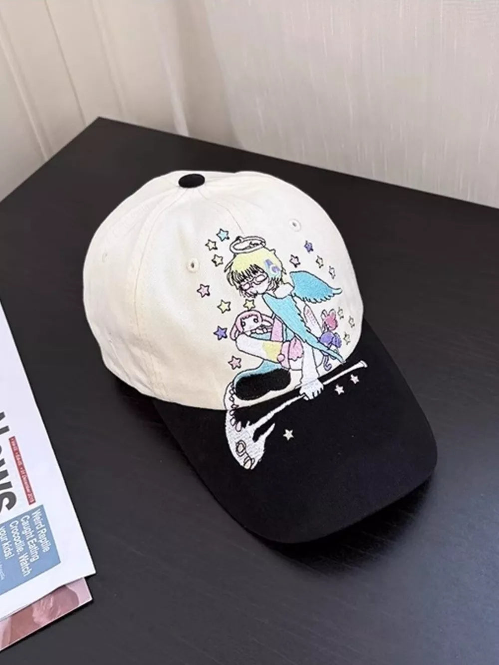 Black and beige cotton baseball cap with whimsical embroidered angel and stars.