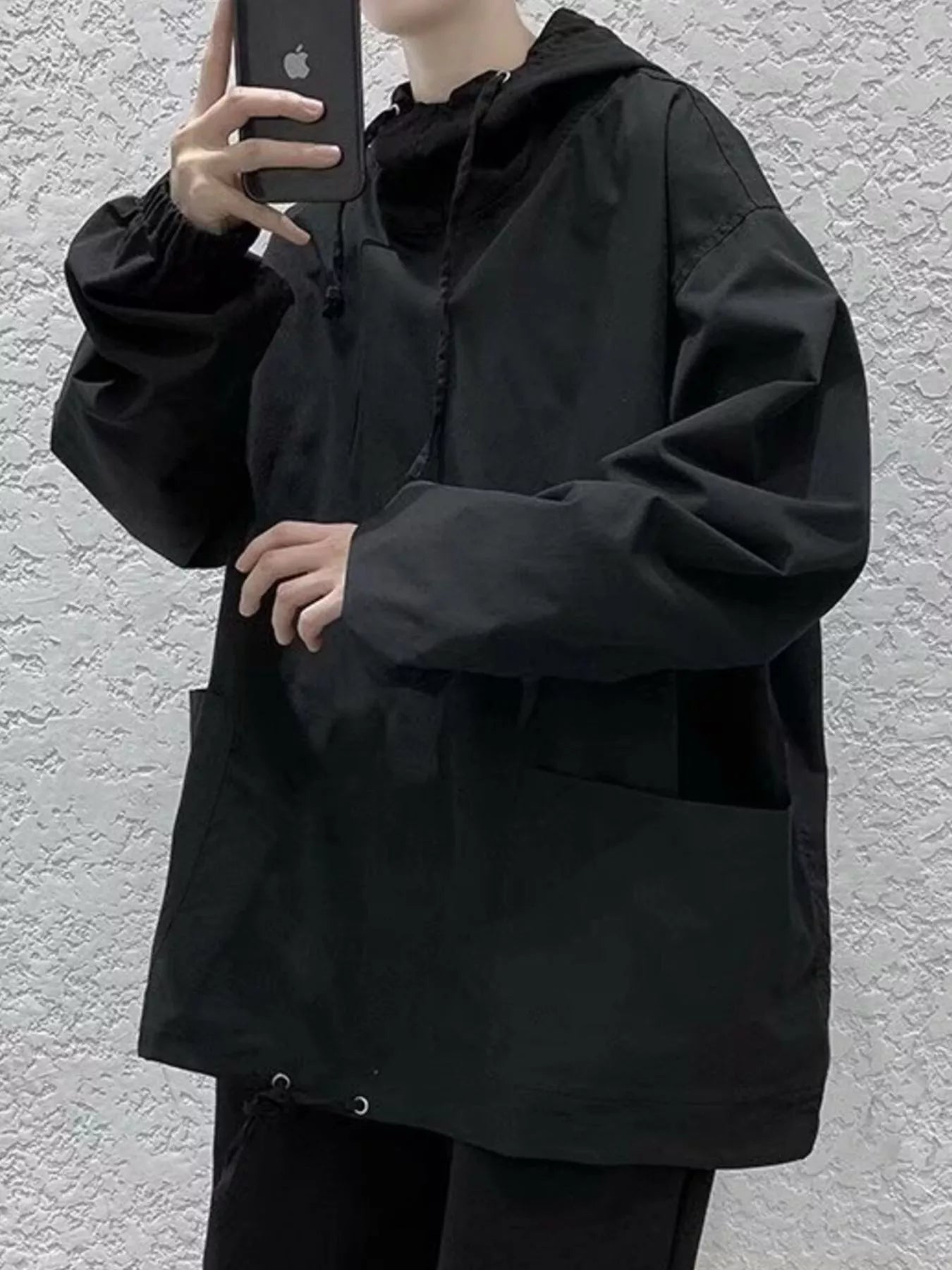 Black oversized drawstring hoodie with front pockets and cinched cuffs.