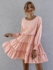 Apricot ruffled mini dress with long sleeves and tiered skirt.