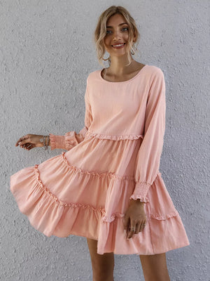 Apricot ruffled mini dress with long sleeves and tiered skirt.